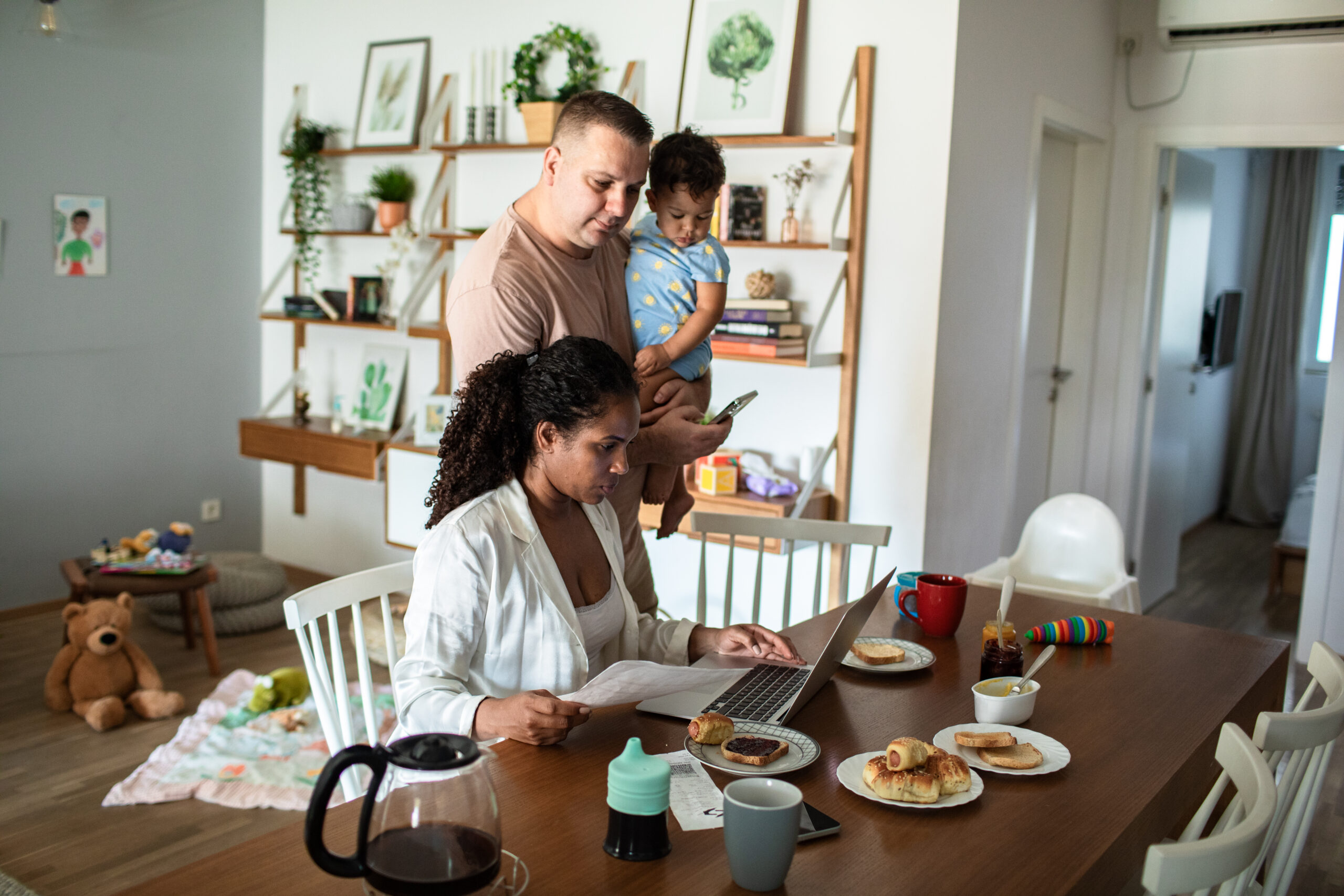 young family having breakfast and using a laptop in the morning