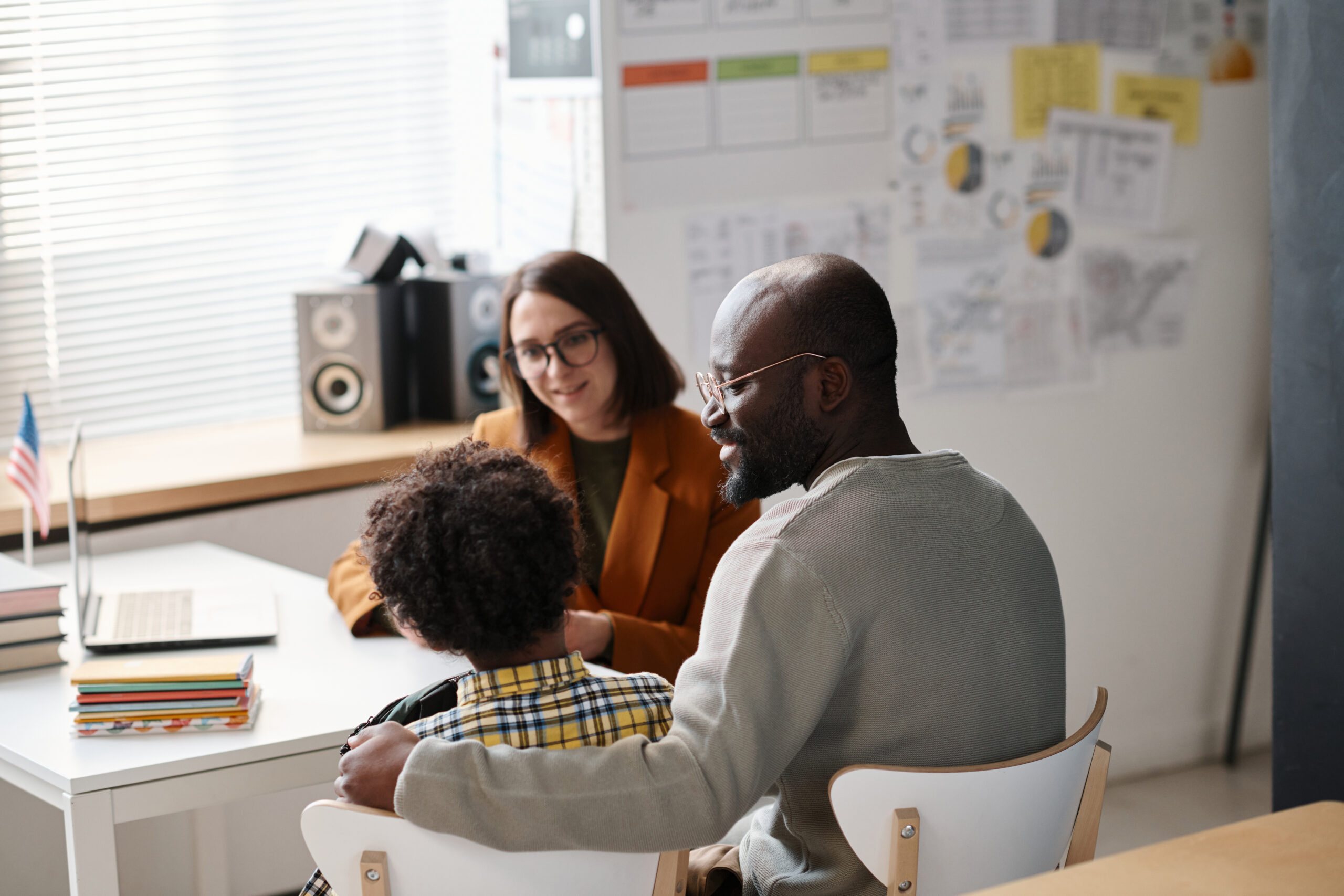 father talking to teacher in classroom