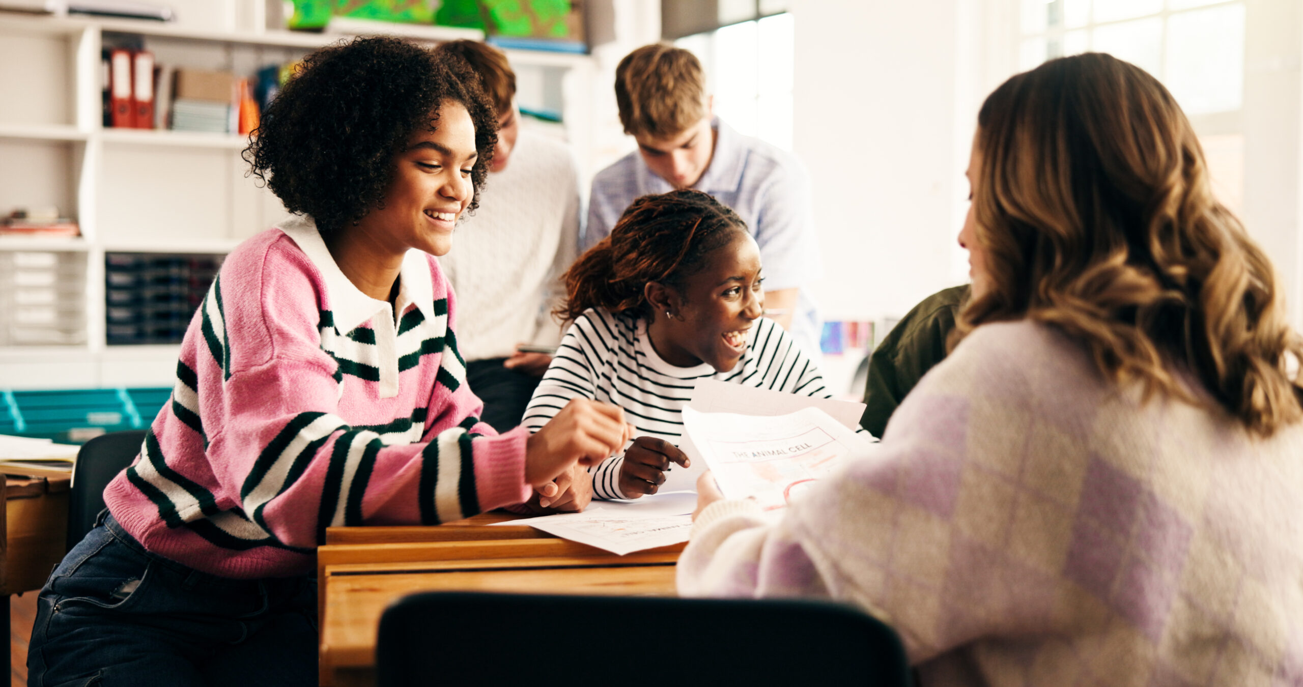 high school, education and girls in classroom, friends and documents with assessment. group project, academic development and students with discussion, smile and test with teenagers and communication