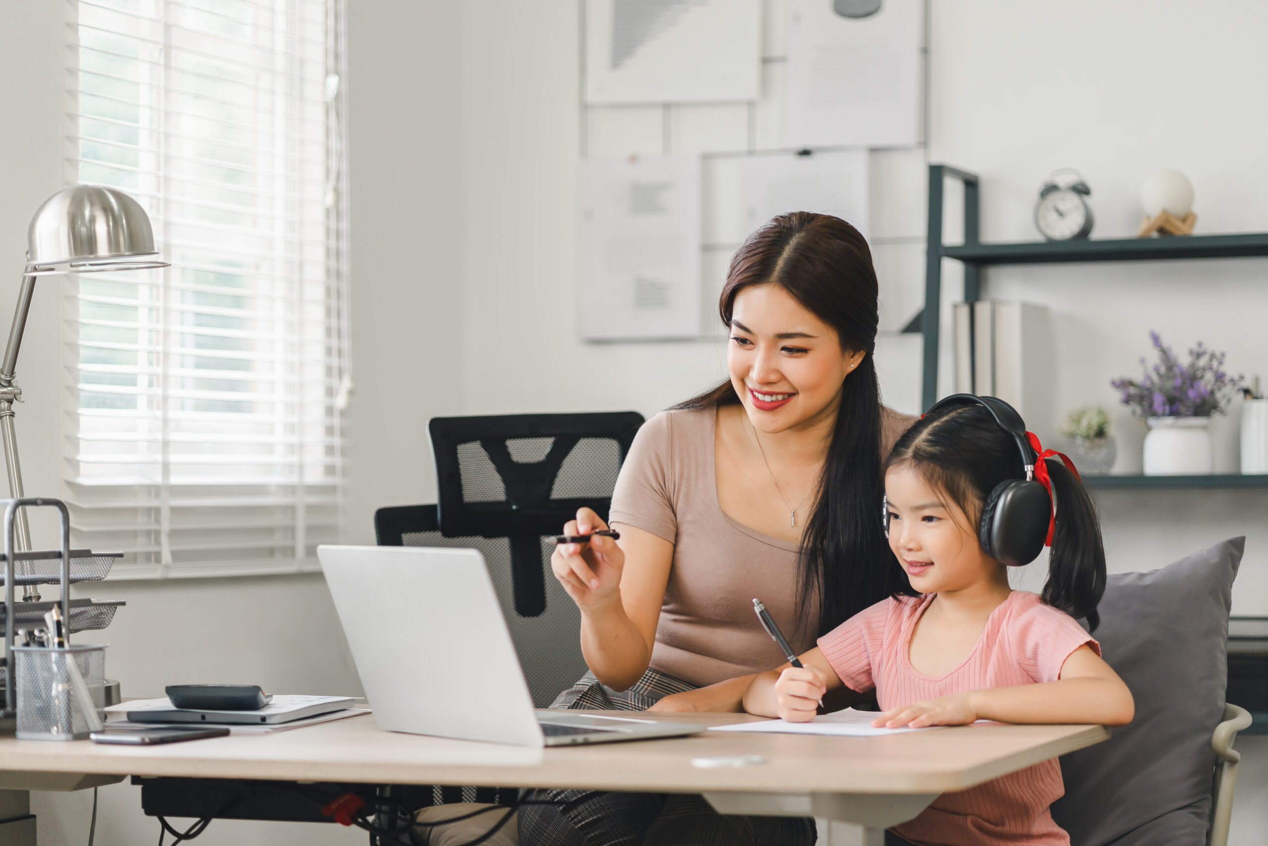 mother helping daughter with online learning.