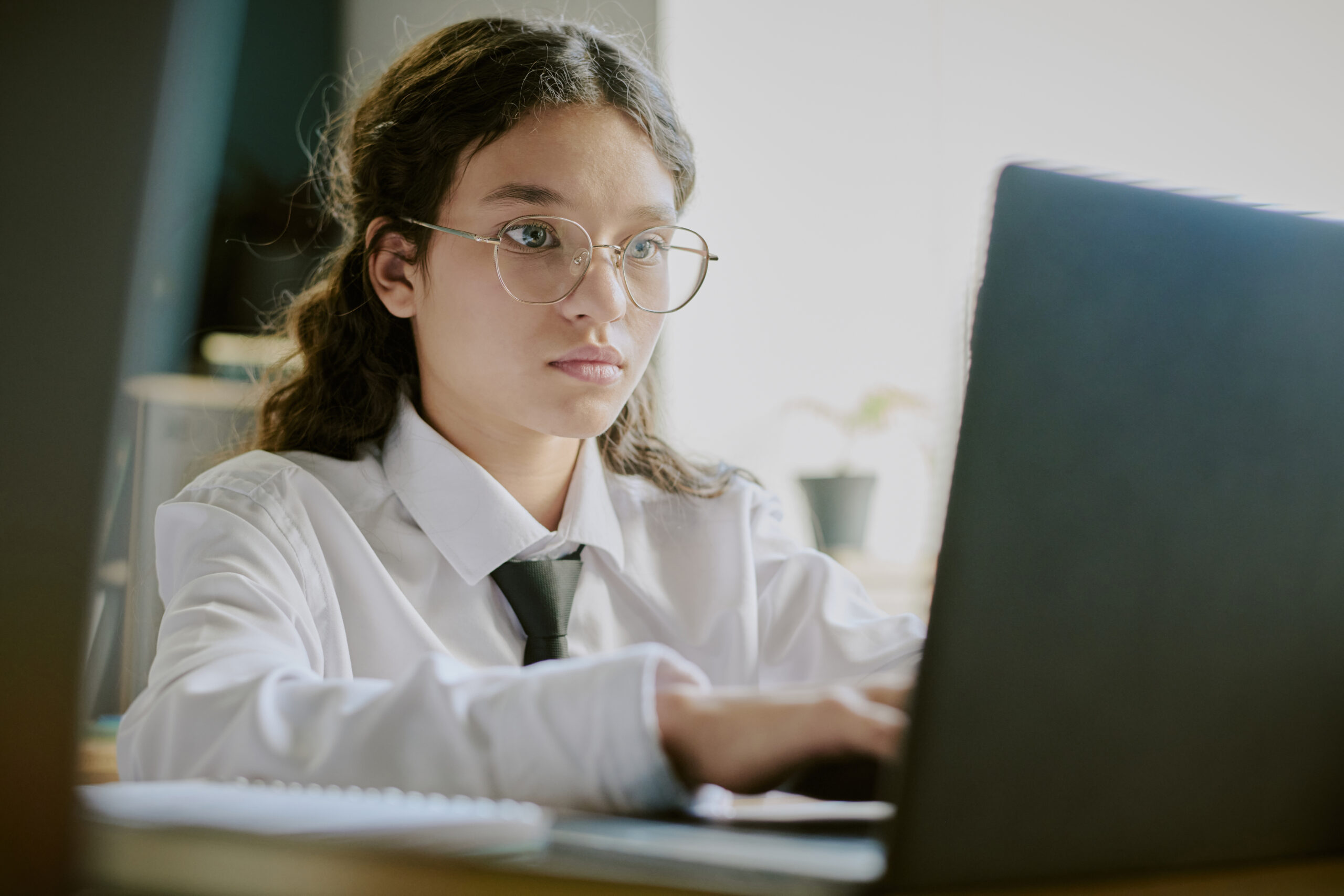 portrait of young student working on laptop in classroom