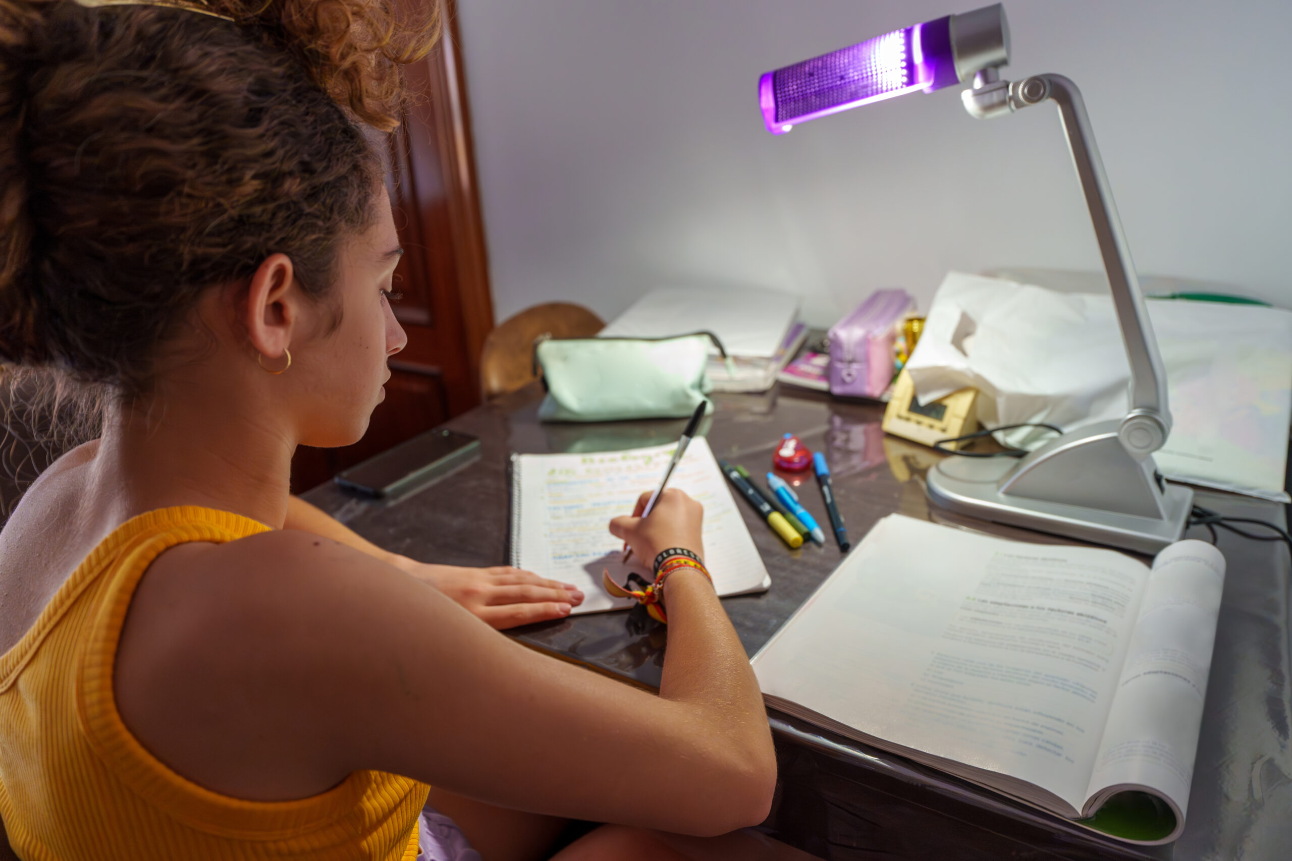 teenage girl studying late at night at home desk