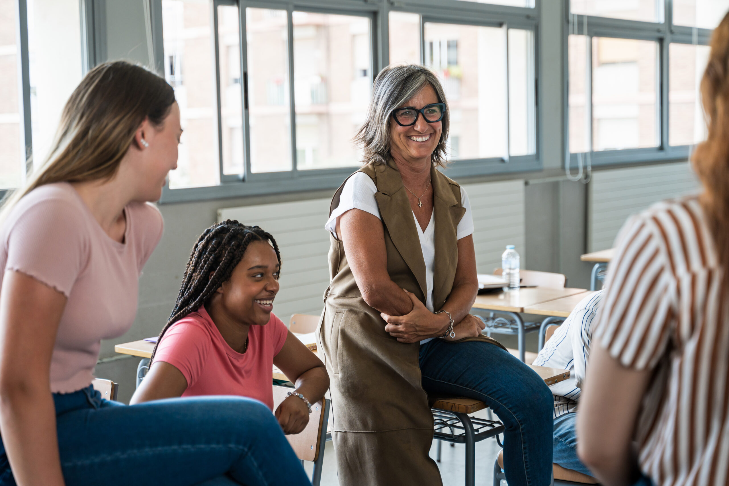 college female students listening to passionate woman professor giving motivational speech at high school