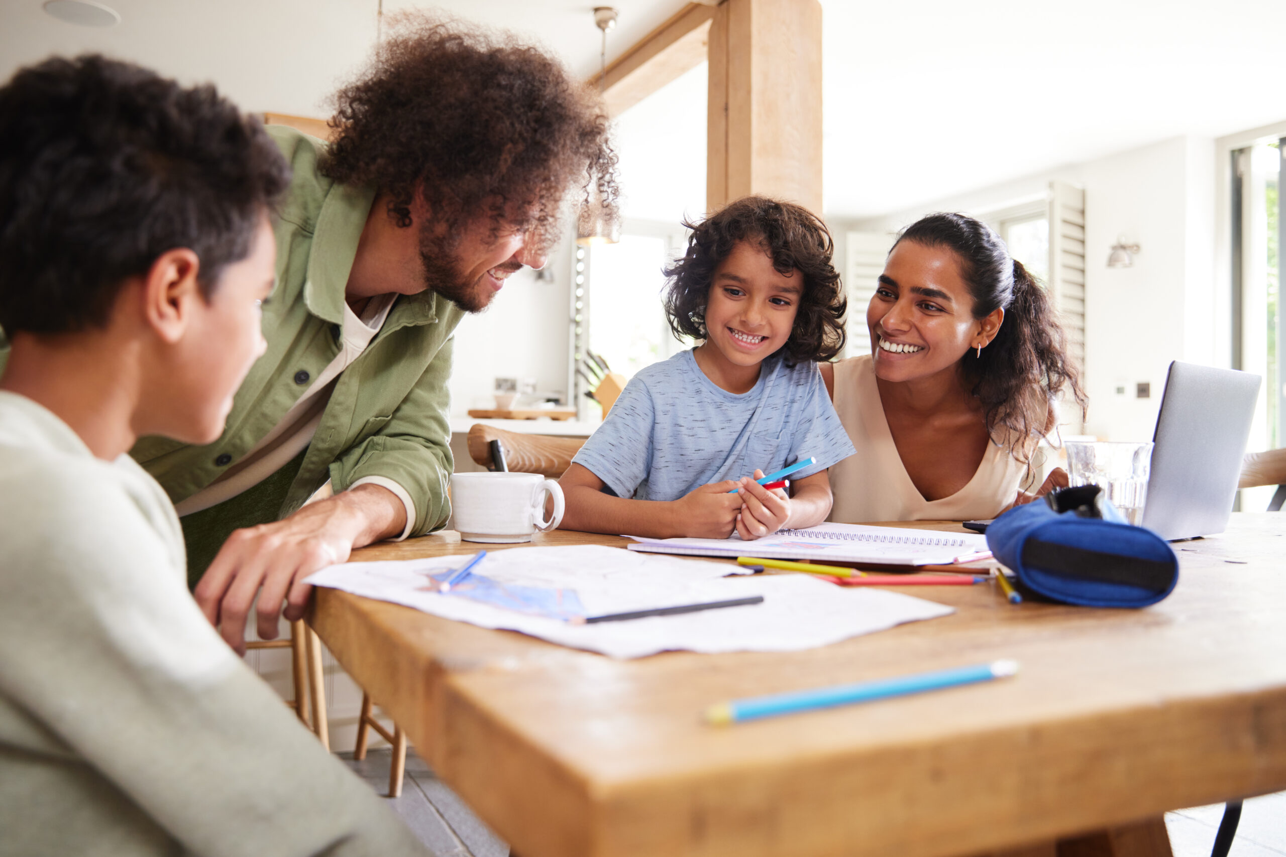 boys drawing at kitchen table with parents