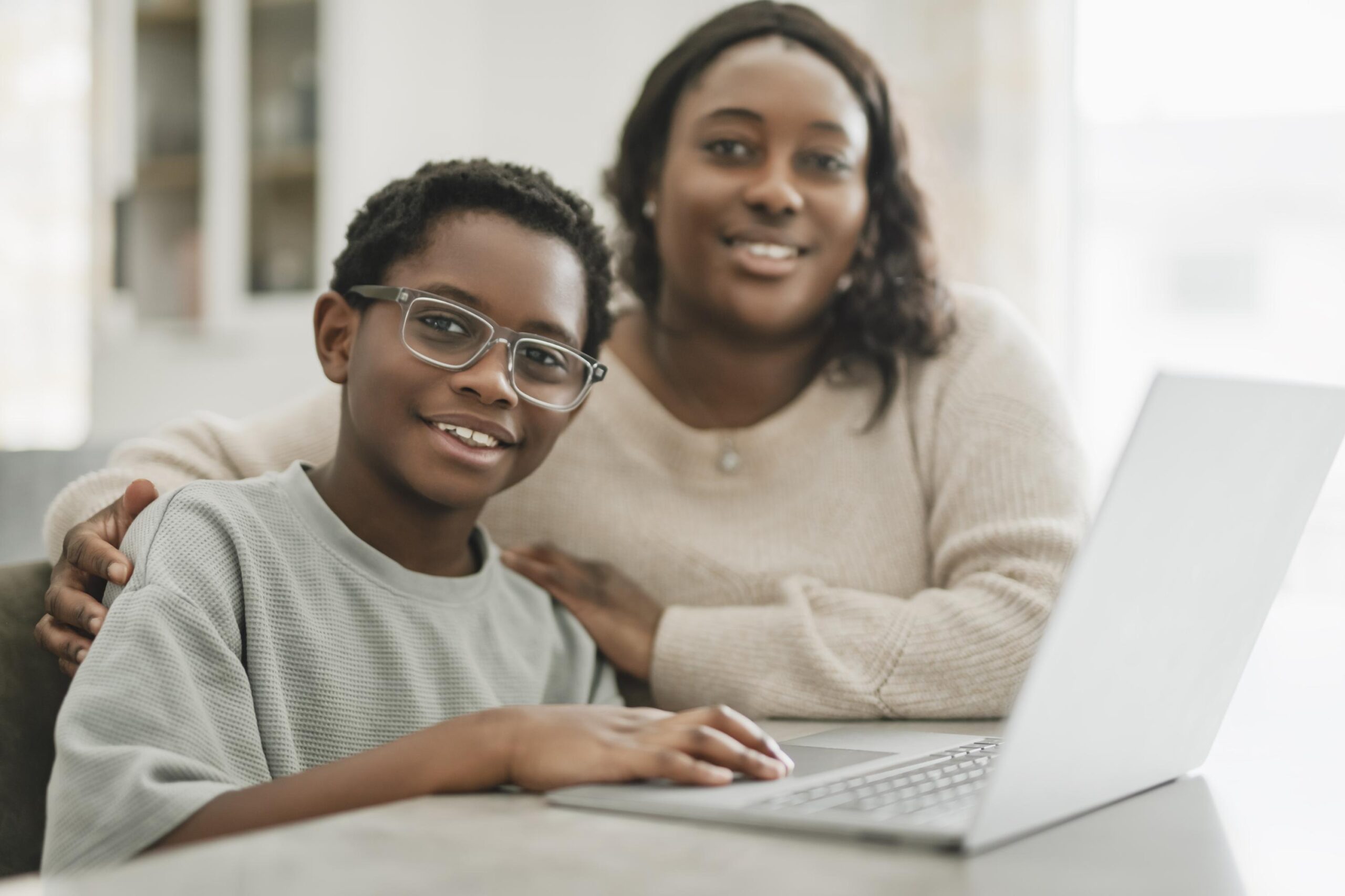 Parent’s Guide 2026: How to Choose a Flexible, Accredited K-12 Virtual School That Fits Your Family little american boy studying online with laptop in kitchen with mother